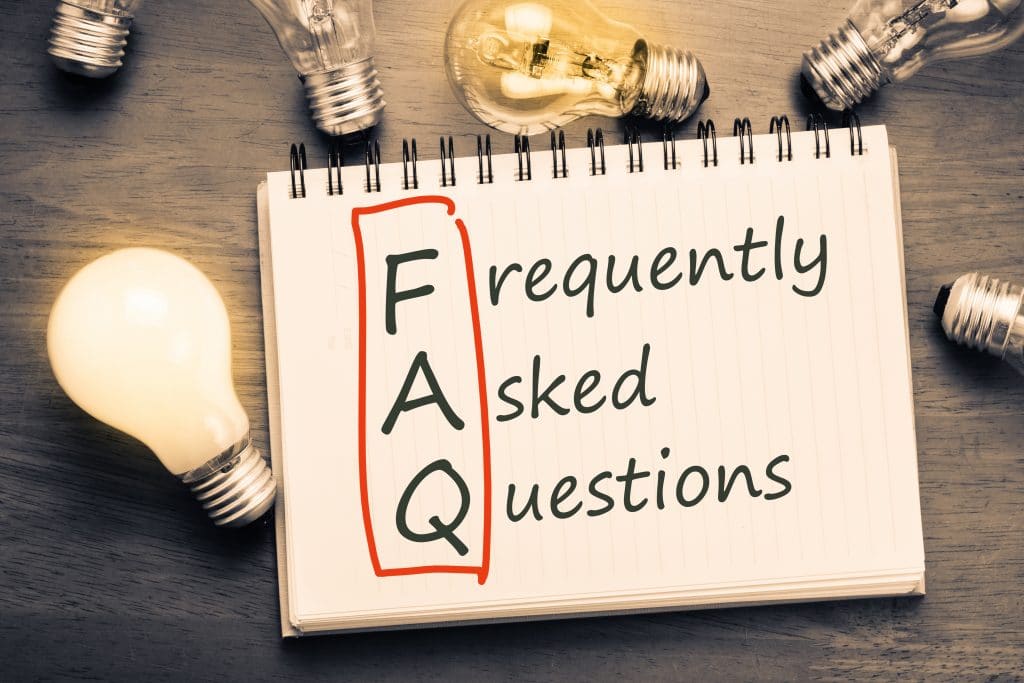 FAQ ( FREQUENTLY ASKED QUESTIONS ) TEXT ON NOTEBOOK WITH MANY LIGHT BULBS